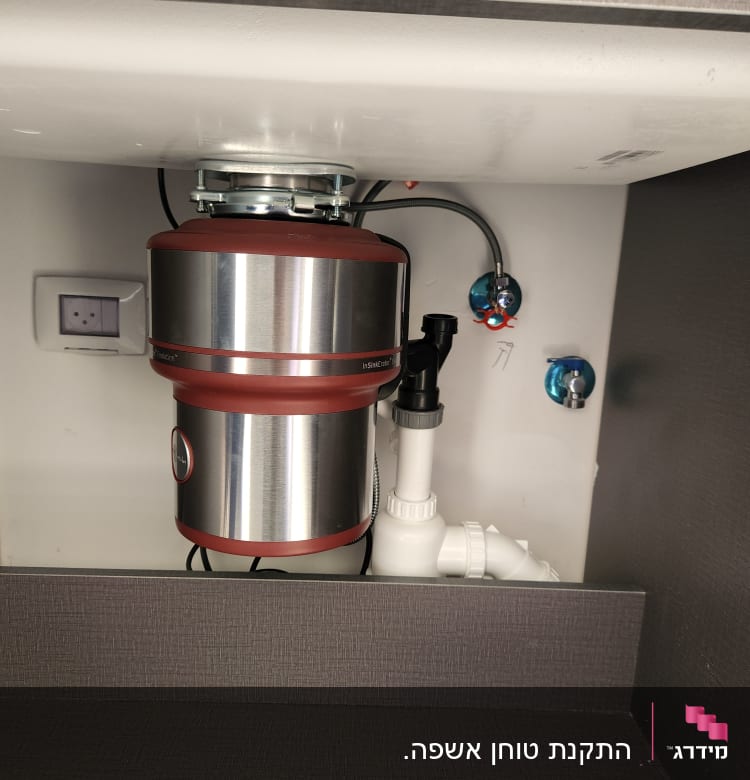 מכשיר טוחן אשפה מותקן מתחת לכיור במטבח